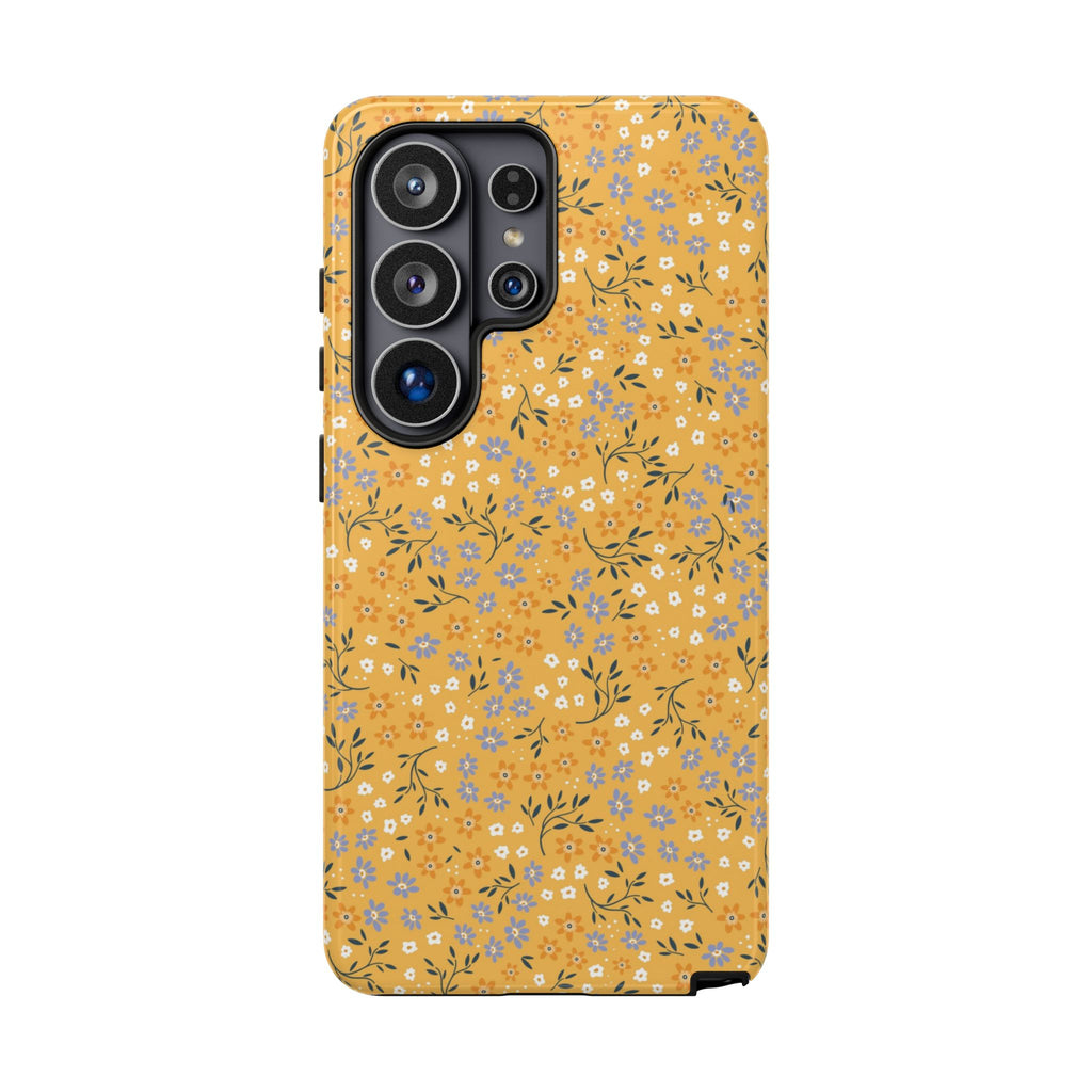 Sunny Side Samsung Galaxy phone case featuring tiny periwinkle blue, orange, and ivory wildflowers with delicate dark green leaves on a mustard yellow background.