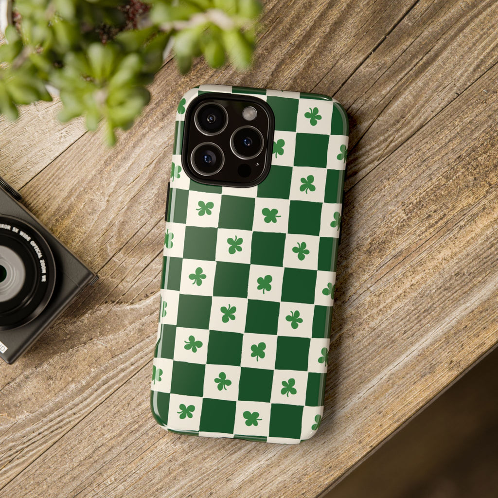 Phone case with green and white checkered pattern on a wooden surface