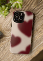 Phone case with a marbled design on a wooden surface next to a camera