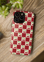 Phone case with red and white checkered pattern and cherry design on a wooden surface.