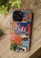 Colorful phone case with abstract designs on a wooden surface next to a camera.