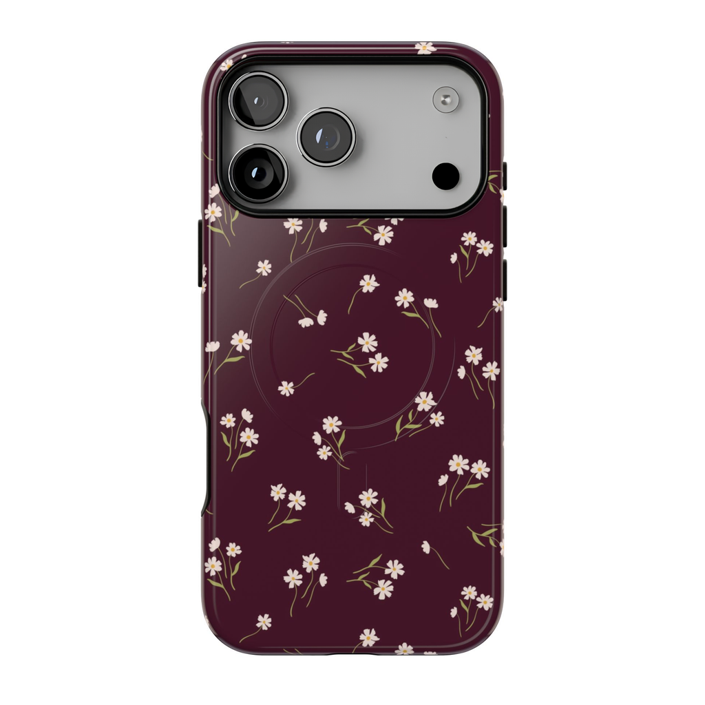 Dainty Daisy MagSafe case featuring tiny ivory daisies with yellow centers and delicate olive-green leaves on a rich burgundy background.
